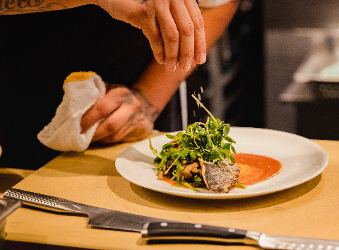 Professional chef plating gourmet food with artistic presentation